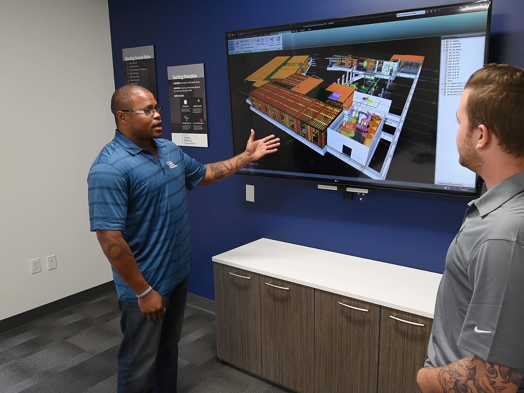 two people discuss model on screen