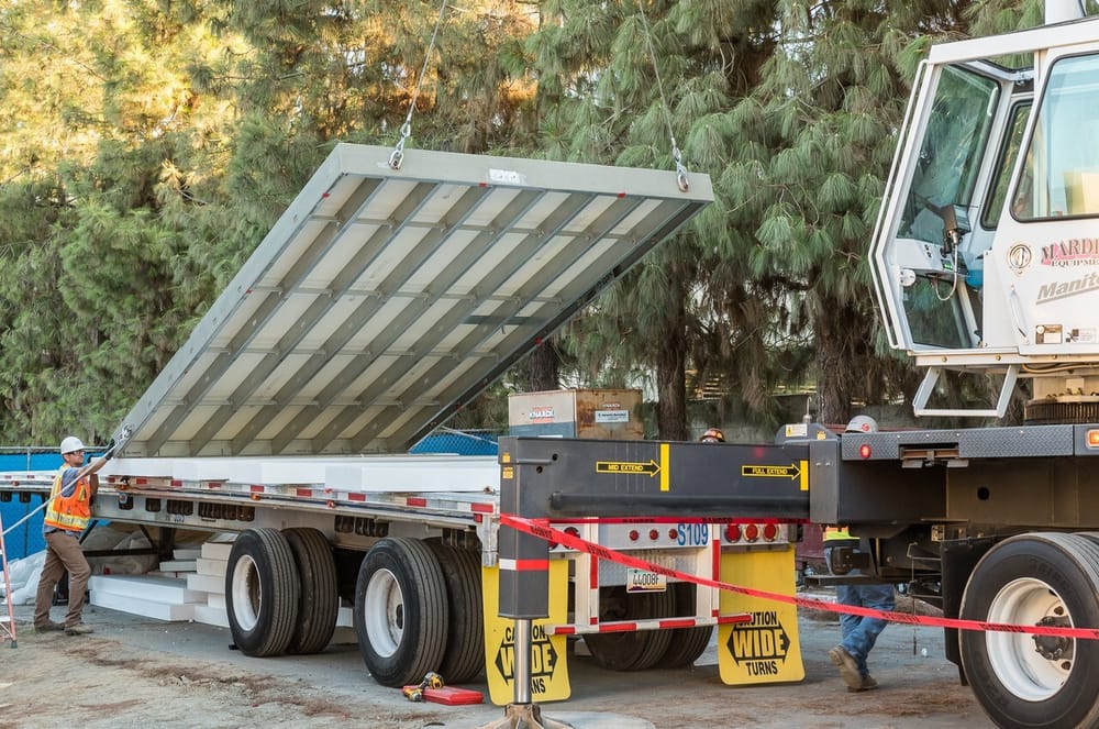 DBC prefabricated exterior panel being lifted by crane off delivery truck