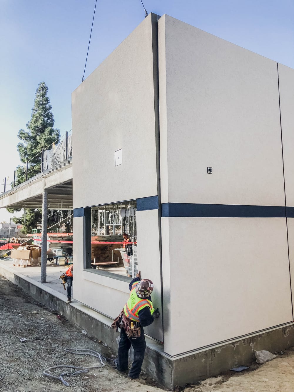 DBC prefabricated panel flying (by crane) into place with two crew members