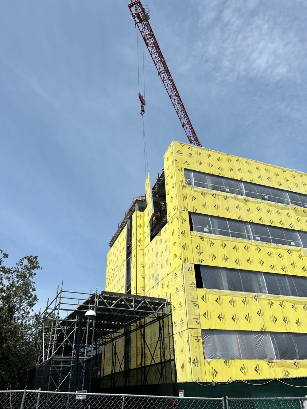 Prefabricated panel hanging by crane during installation