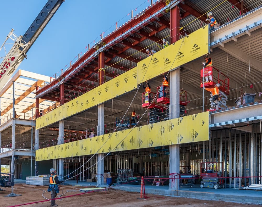 DBC's prefabricated exterior panel flying into place (by crane) with install team