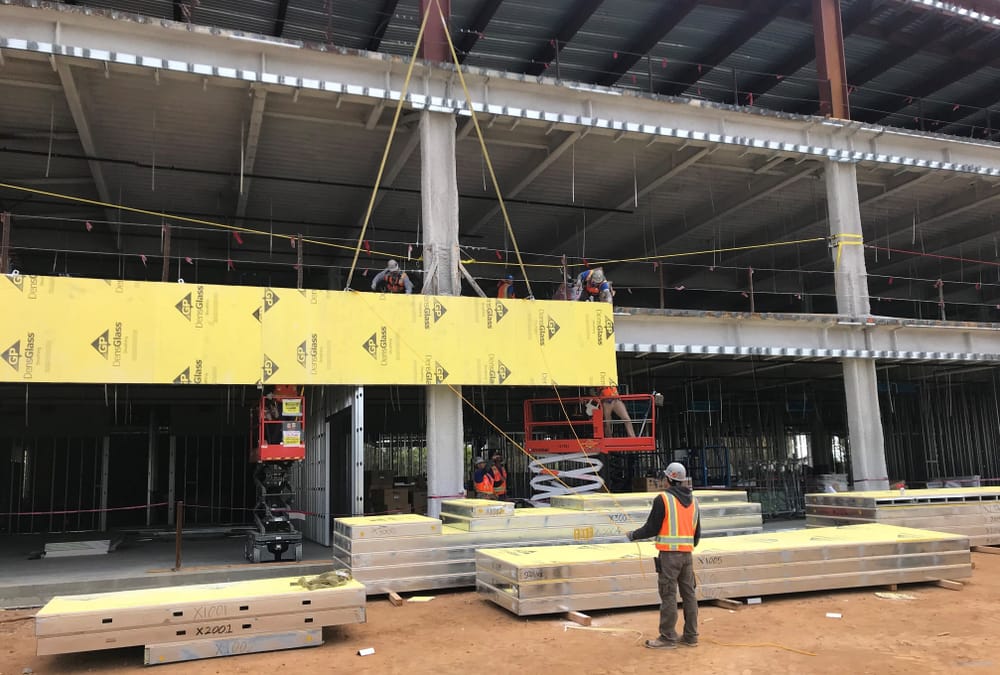 DBC's prefabricated exterior panel flying into place (by crane) with install team