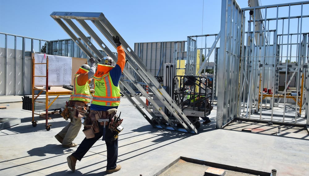 Install crew team lifting DBC prefabricated structural panel into place