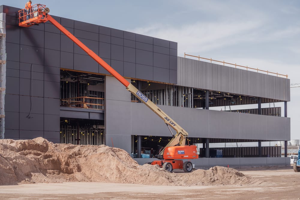 Man on cherry-picker inspecting DBC's prefabricated exterior panel