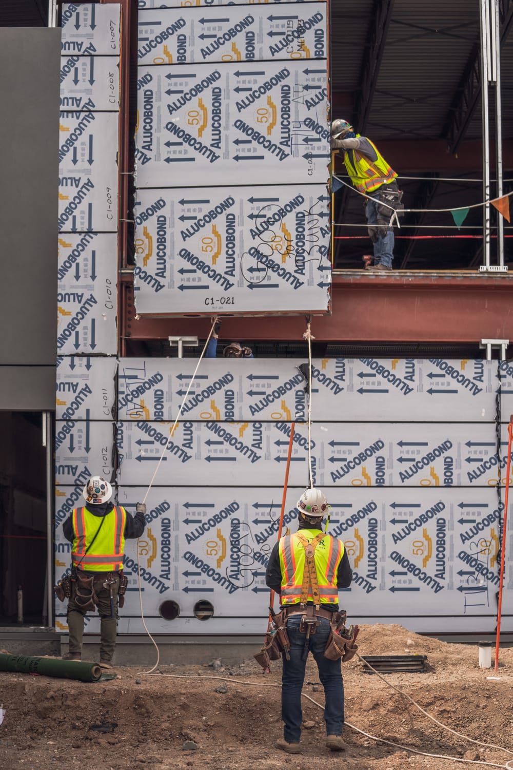DBC's prefabricated exterior panel flying into place by crane with three crew members
