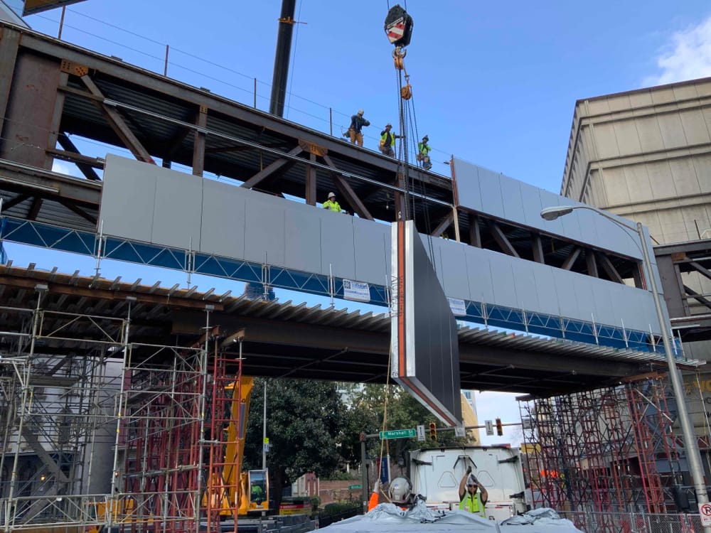 DBC prefabricated panel flying into place (by crane) for an above-street bridge to the main hospital branch