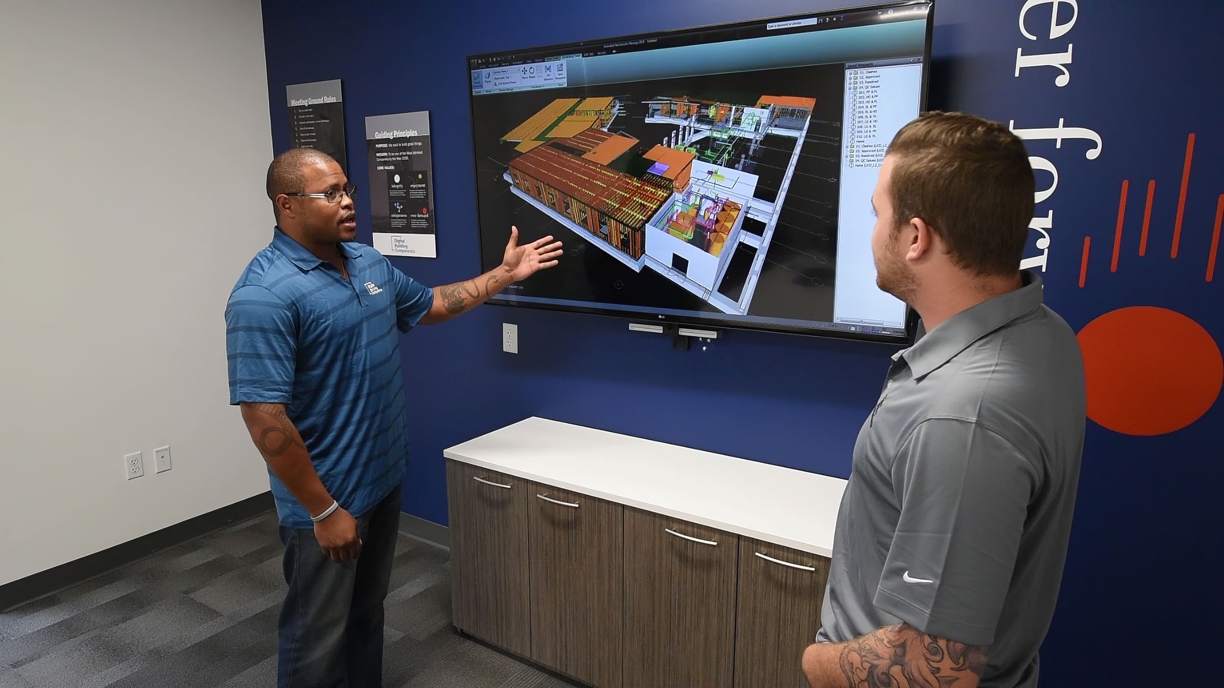 two people discuss model on screen