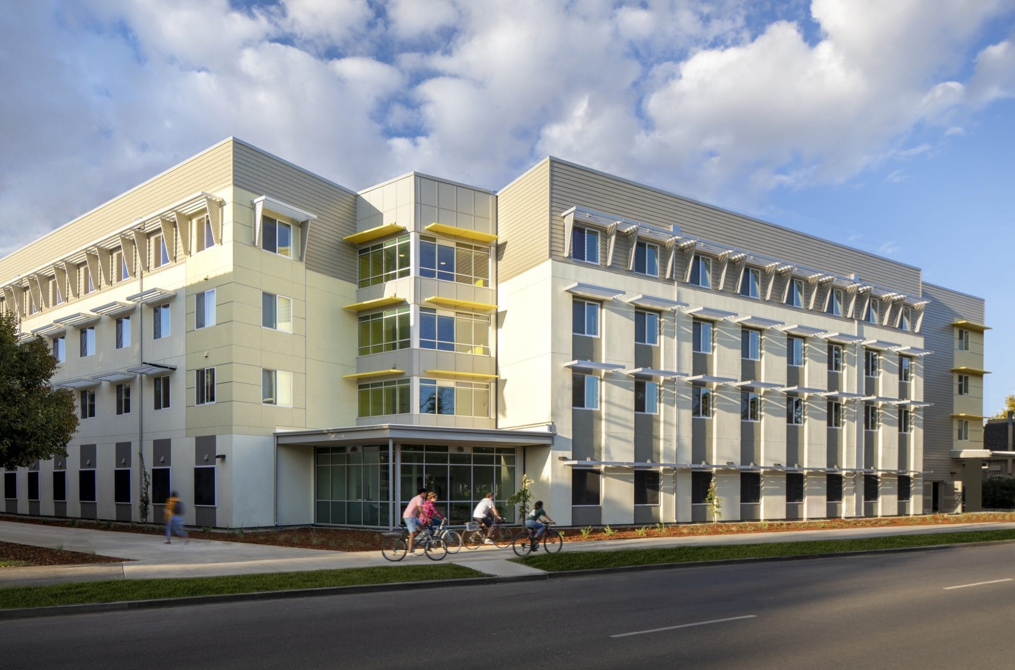 Exterior rendering of a four story builder with cyclists in the foreground.