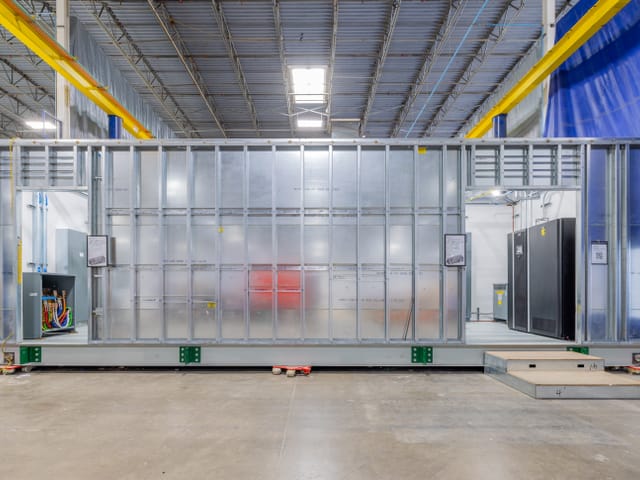 Modular electrical room sitting in a warehouse.