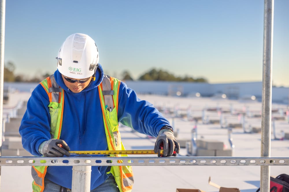 a construction professional working on a solar panel system on a roof