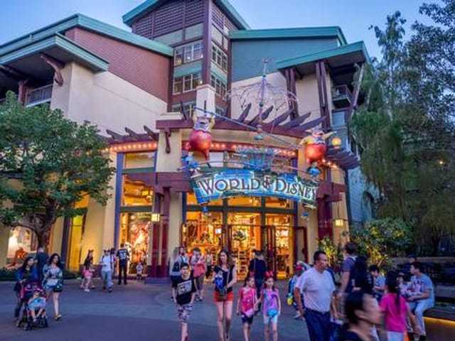 The store front of World of Disney with people walking in front of it