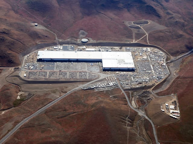 View from above of an L shaped building with a white roof
