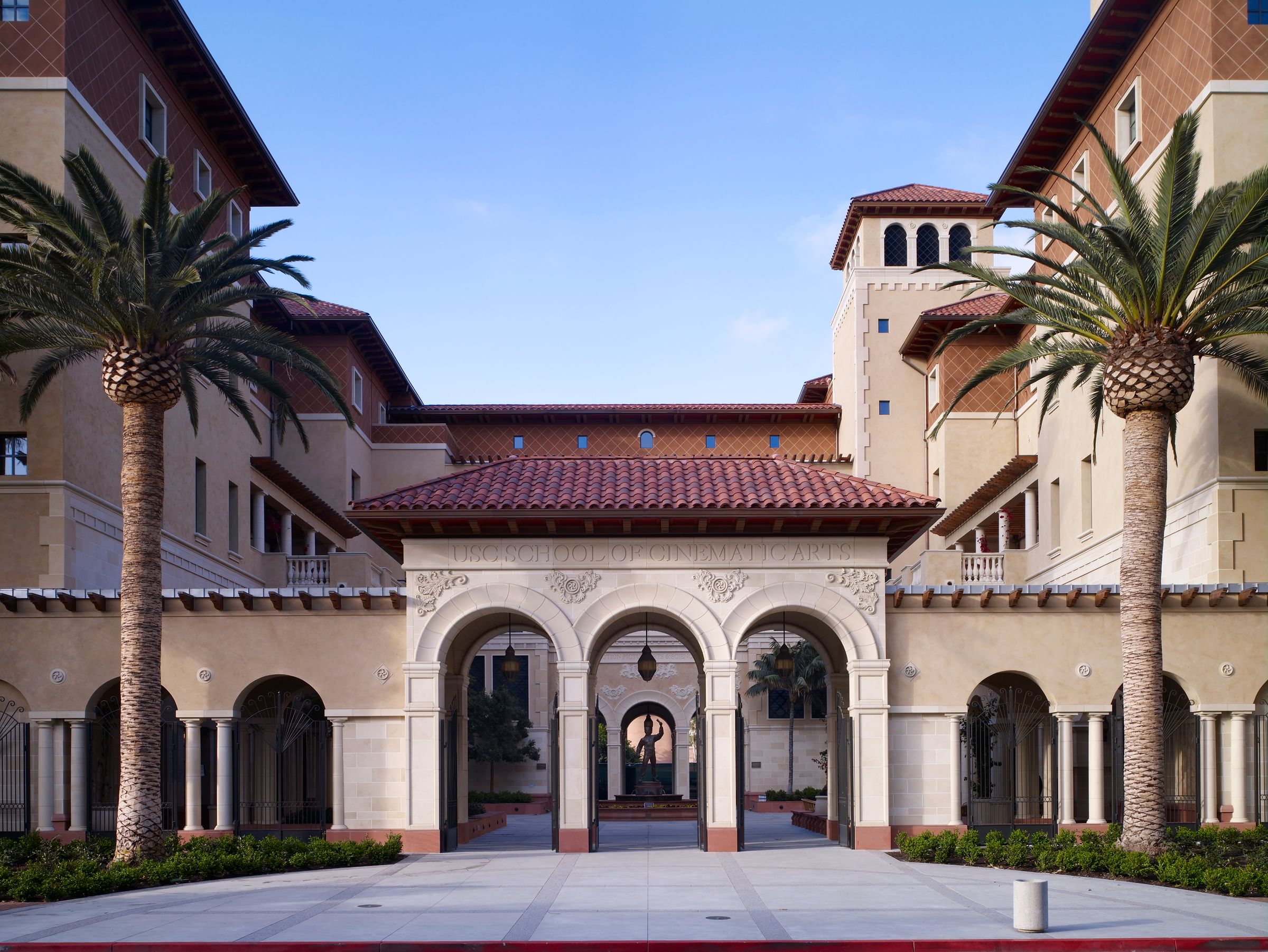 A roman architecture style building with palm trees on the side