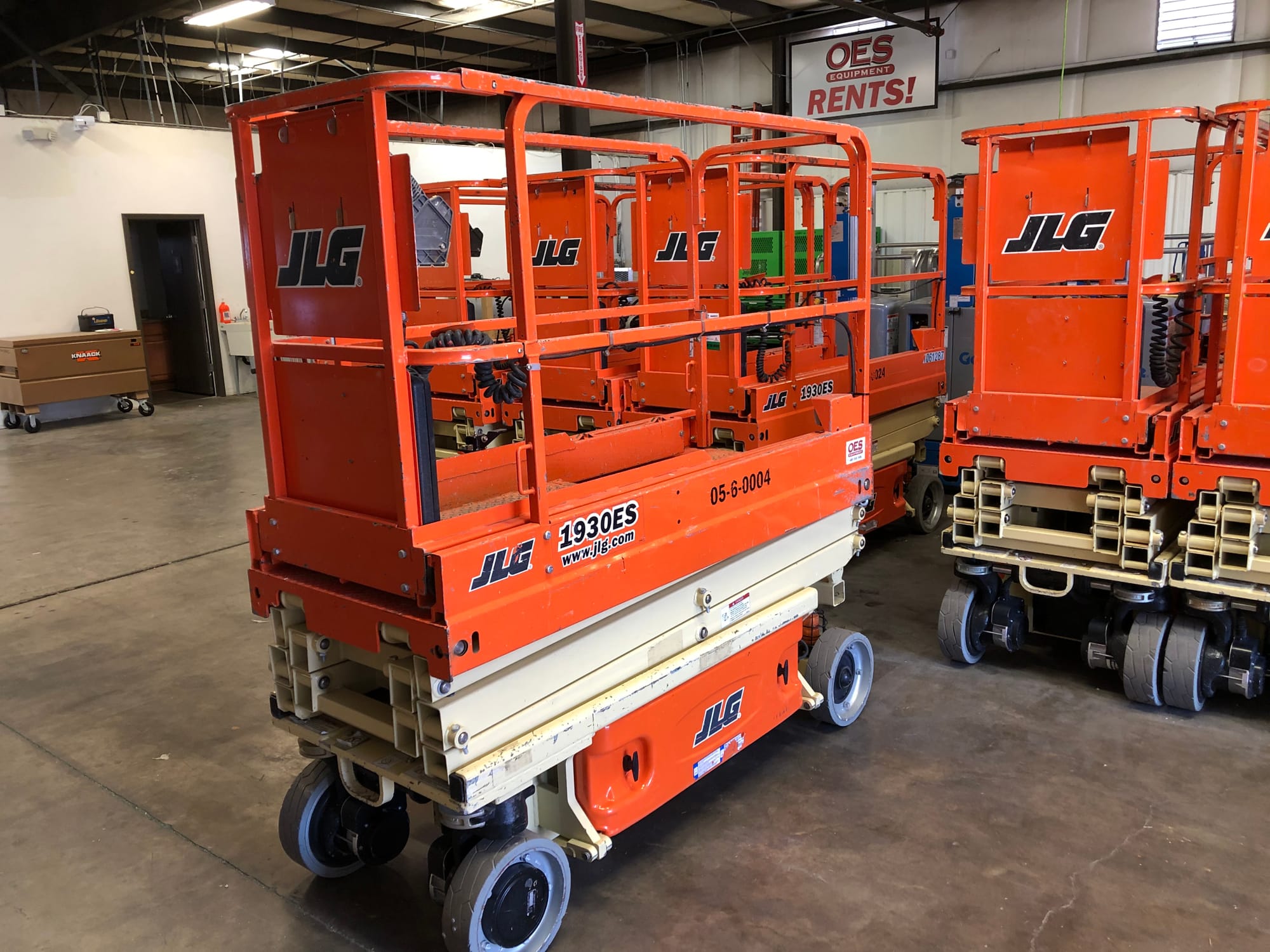 a scissor lift in its down position in a warehouse