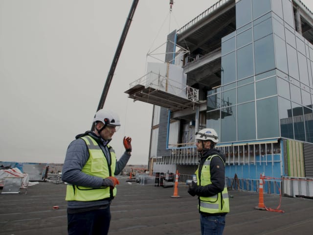 Two construction workers outside a jobsite