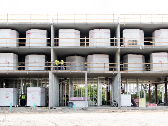 Rows of bathroom pods lined up inside building
