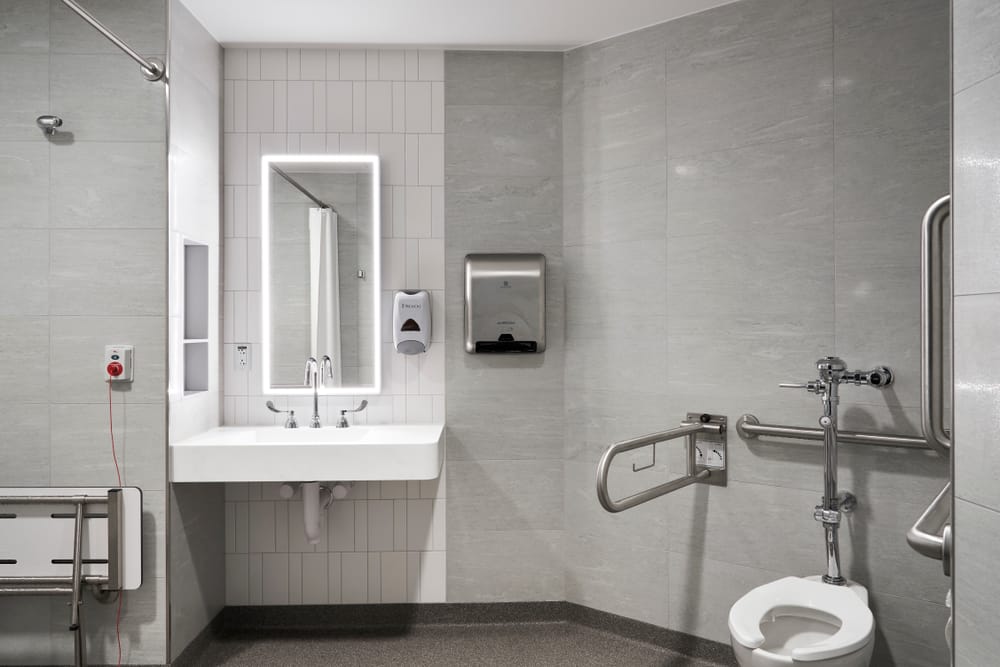 Atrium Health Carolinas Rehabilitation Interior Photo Bathroom Pod including sink, mirror, toilet, and hand rails