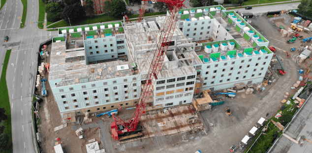 aerial drone footage of building in progress with crane