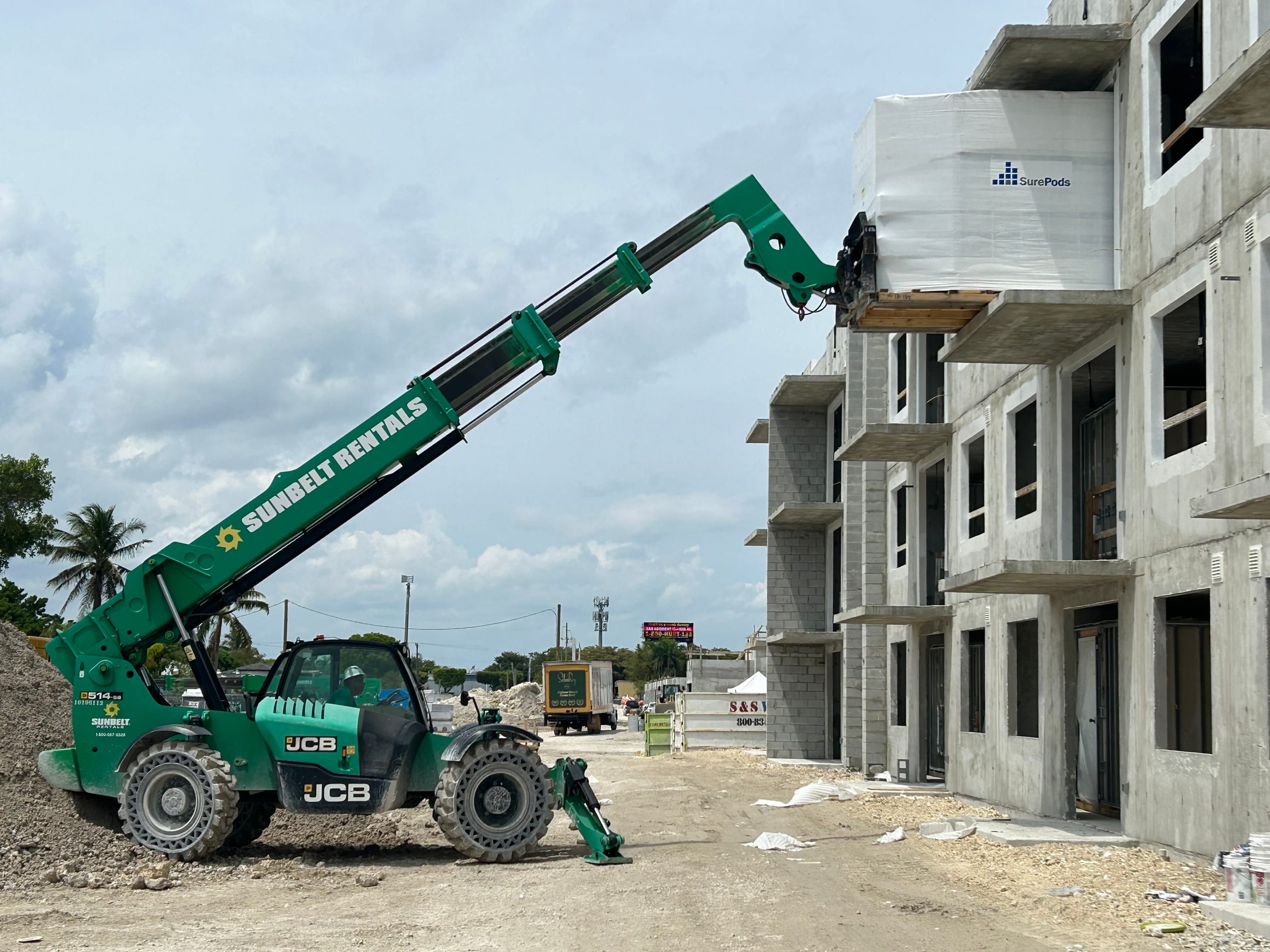 Crane setting bathroom pod into building