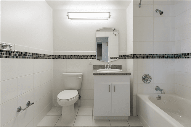 Inside bathroom with white toilet, shower and vanity