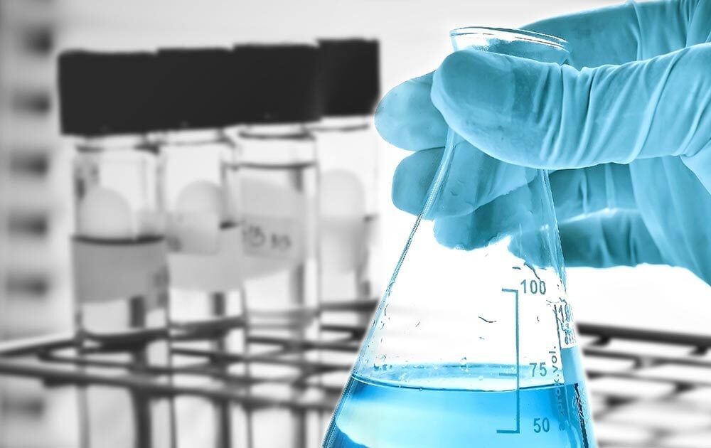 A test tube of blue liquid is picked up.