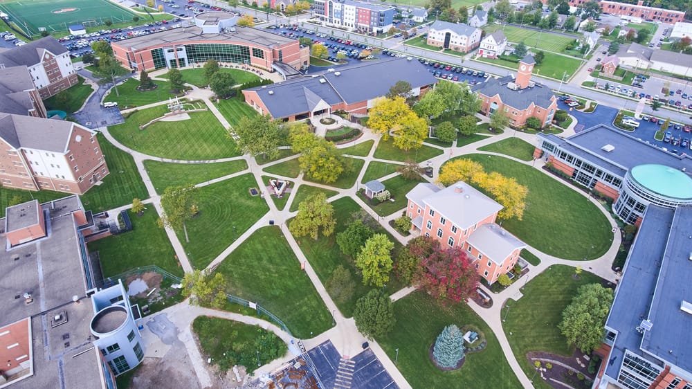 An overview of a large college campus with many buildings and outdoor green spaces.